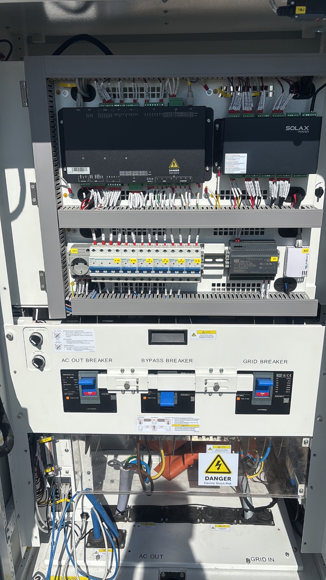 Interne bekabeling en breakers (AC out, bypass, grid) van de SolaX Aelio