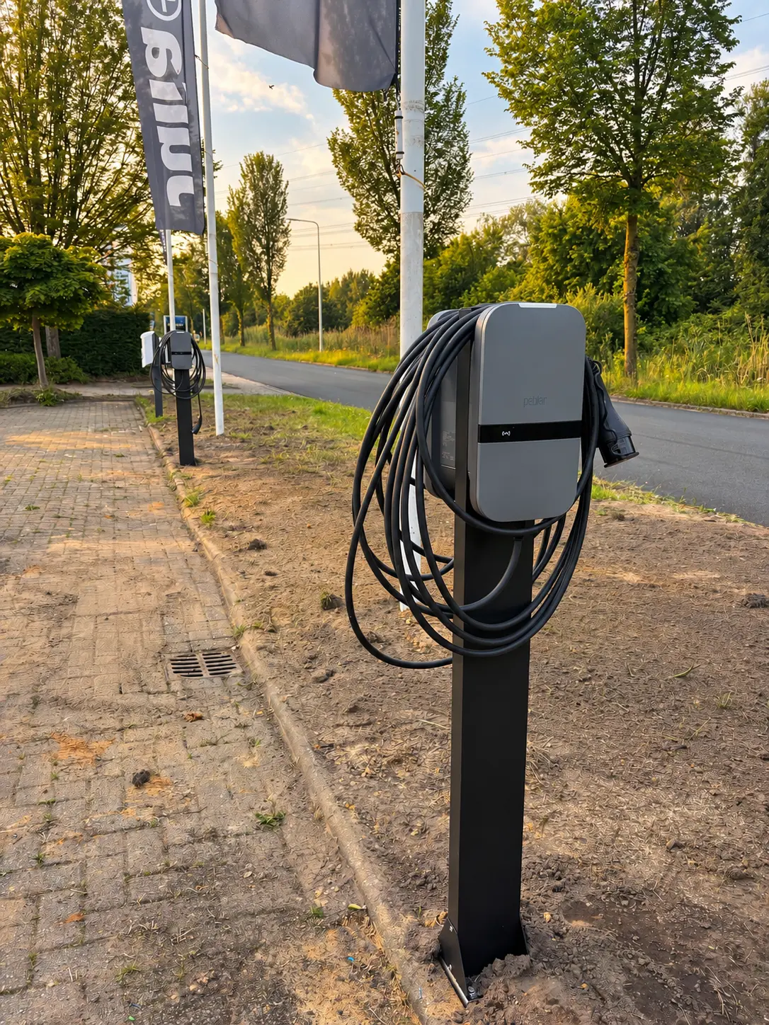 Twee Peblar laadpalen op vrijstaande palen bij een zakelijke locatie
