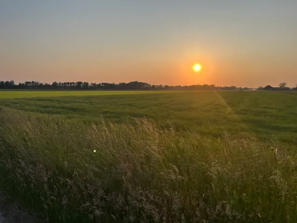 Boerderij bij zonsondergang met duurzame energievoorziening