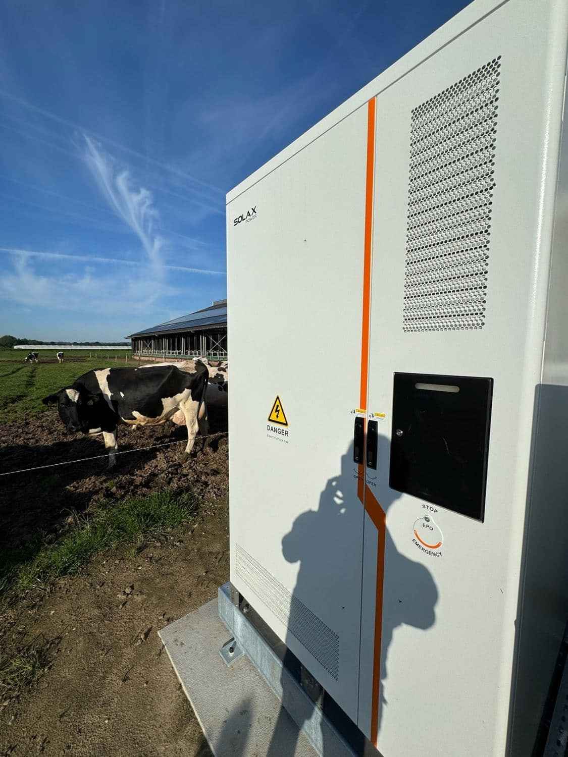 SolaX batterijsysteem met noodstroom geïnstalleerd bij een melkveebedrijf, koeien in de wei op de achtergrond