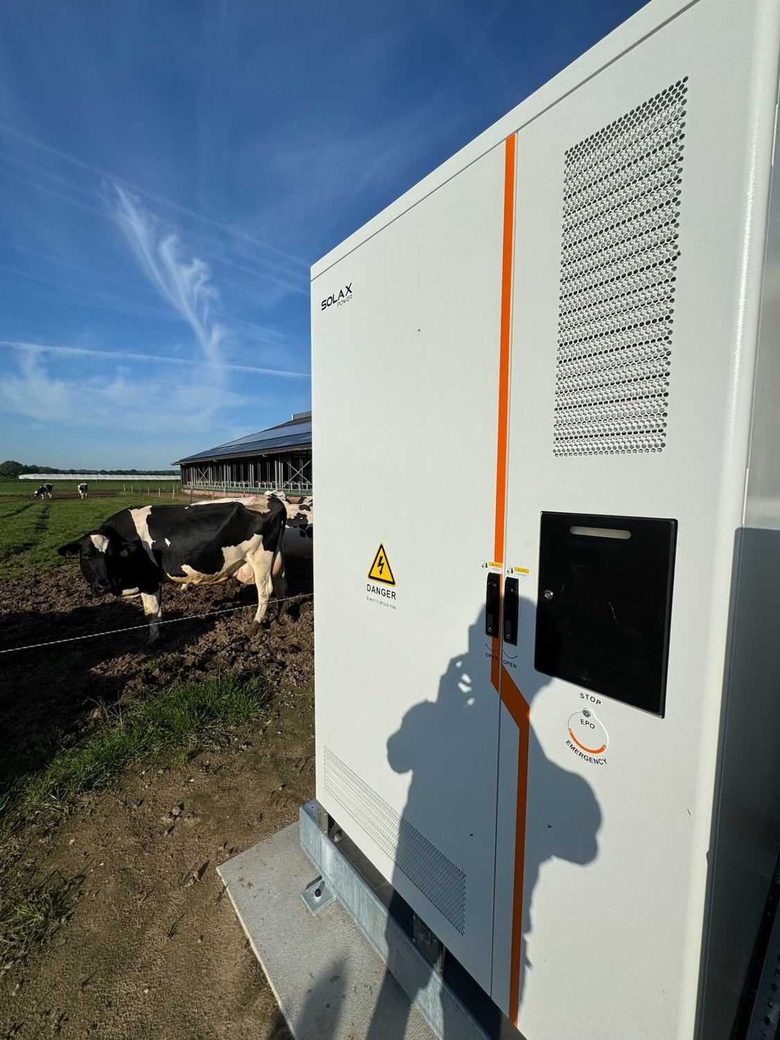 SolaX batterijsysteem met noodstroom geïnstalleerd bij een melkveebedrijf, koeien in de wei op de achtergrond