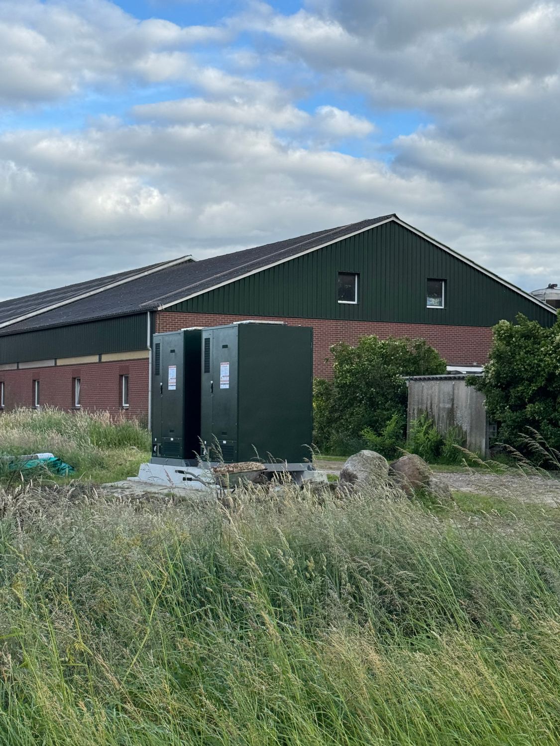 Twee SolaX batterijkasten opgesteld naast een melkveestal