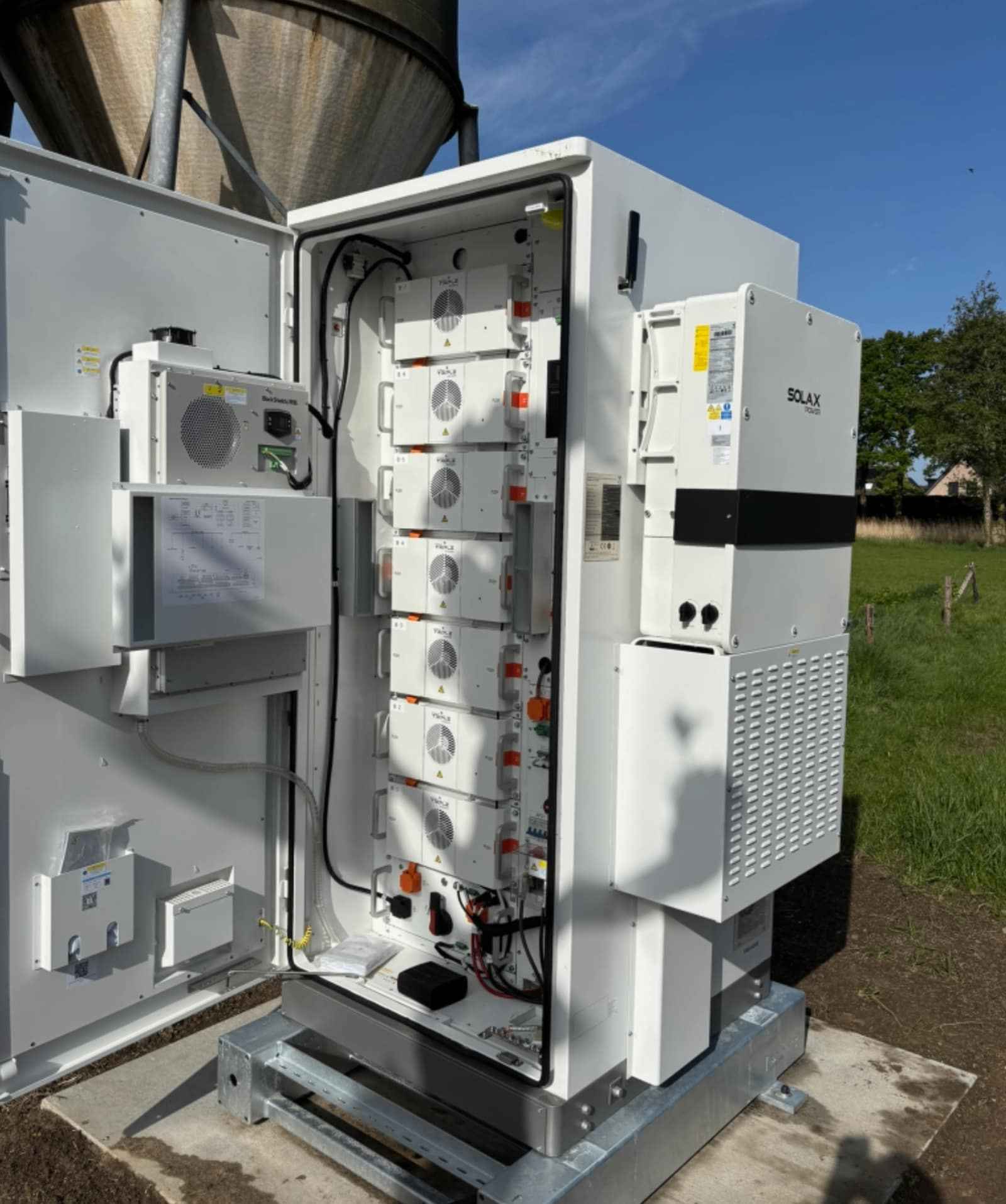 SolaX Aelio-50K met B100 batterijkast bij de woning, open kast met zichtbare batterijmodules en omvormer